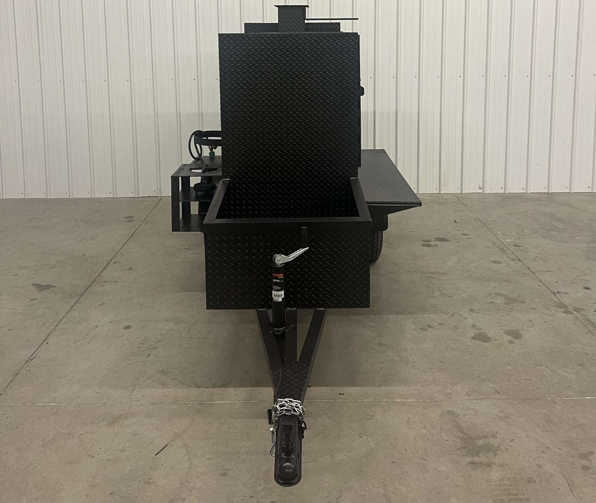 Front view of SNS 60 Cabinet Trailer Smoker made of 1/4 inch diamond tread steel with open main smoker cabinet and firebox with trailer hitch.