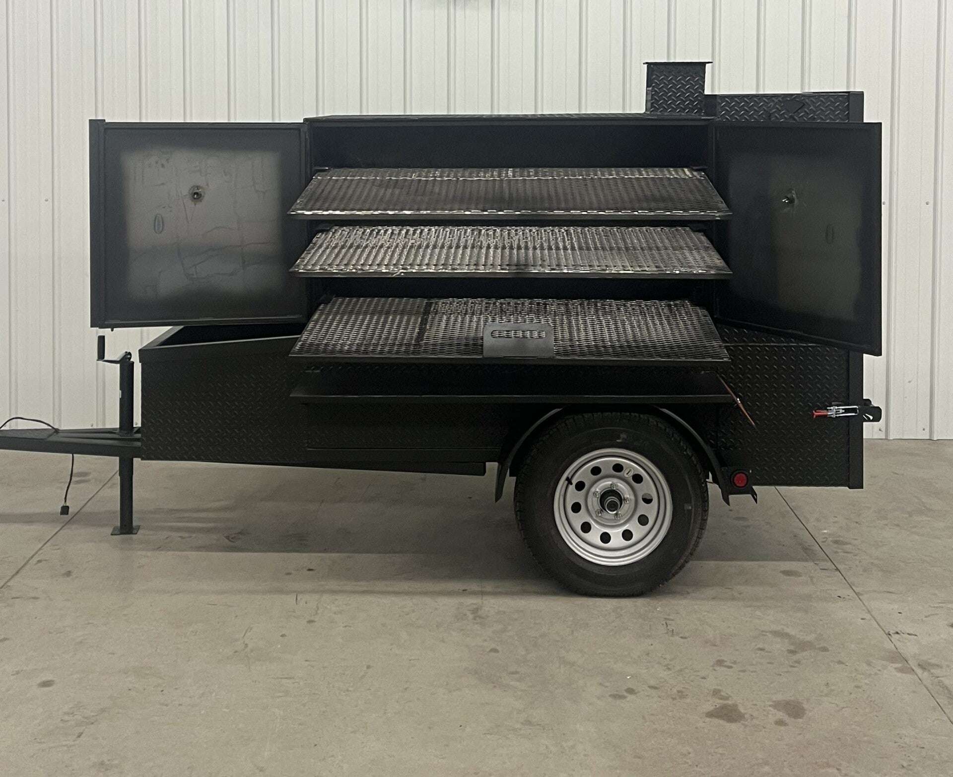 SNS 60 Cabinet Trailer Smoker with three slide-out racks and insulated firebox on single axle trailer