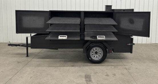 SNS Beast Cabinet Smoker with six slide-out cooking racks and insulated firebox on trailer for large capacity smoking