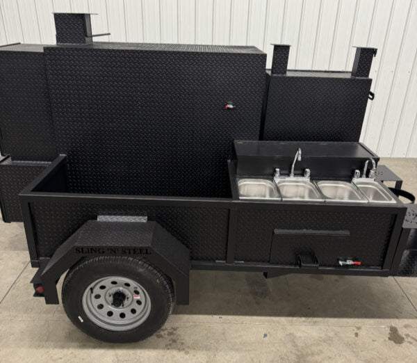 Black BBQ pit catering trailer with triple sink package and stainless steel grills on single axle