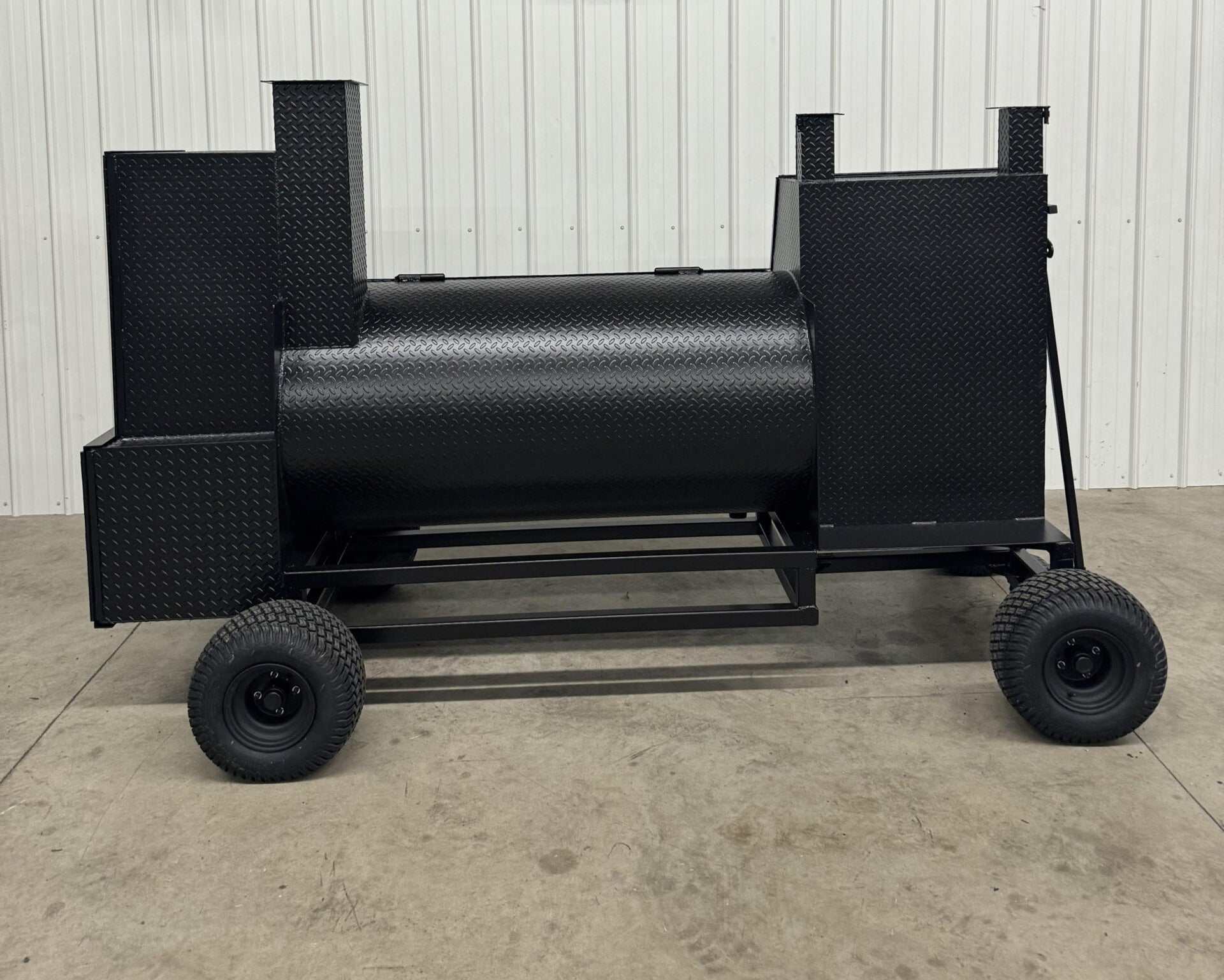 SNS Competition Wagon Smoker with grill made of 1/4 inch rolled diamond tread steel, featuring double-walled insulated firebox, rib/warming box, charcoal grill, and wagon chassis with pull handle for backyard BBQ.