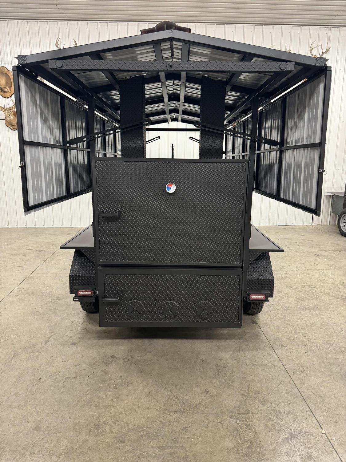 Commercial Avery cabinet smoker with large cooking chamber and dual doors open in industrial setting