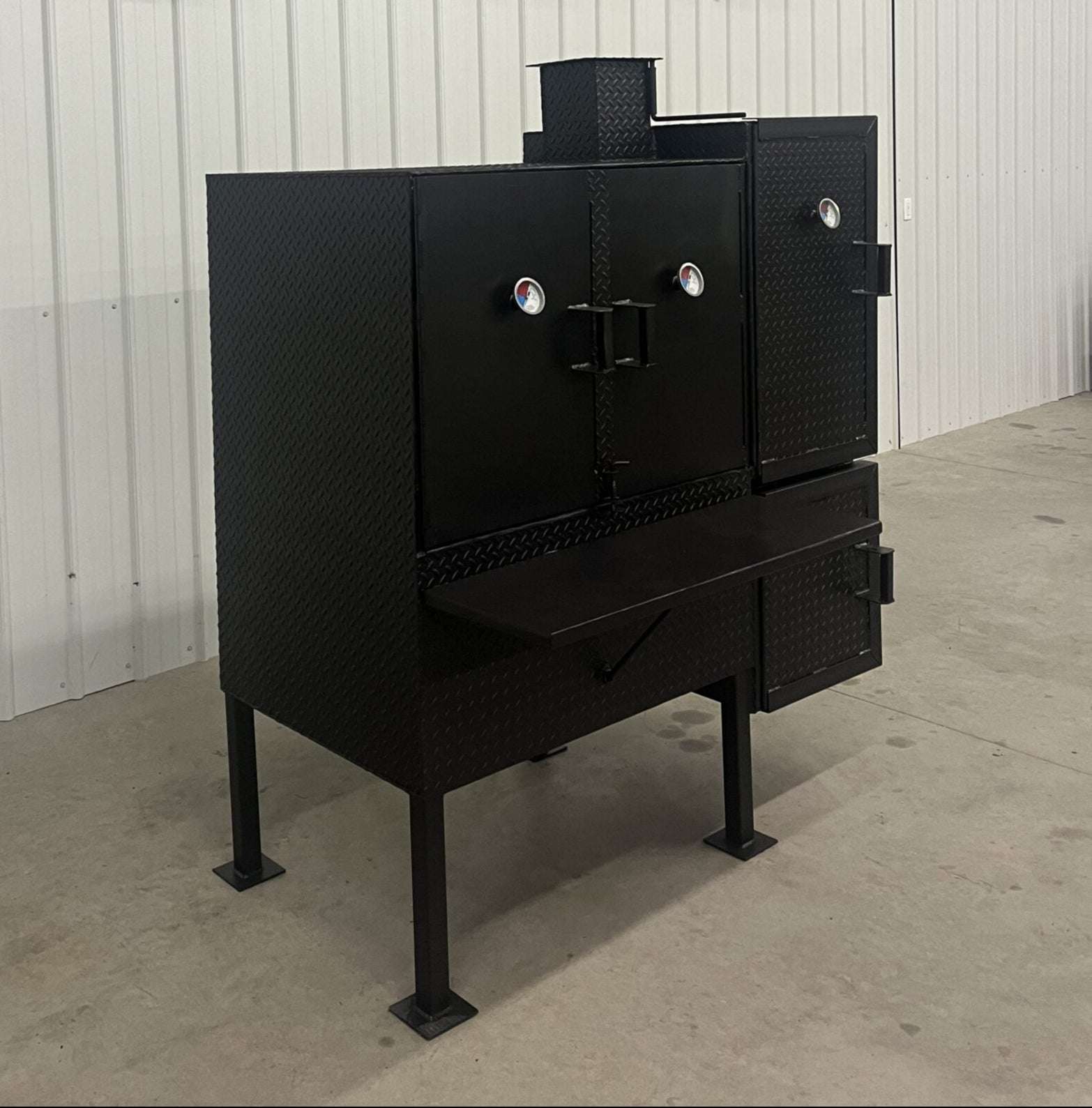 Large black SNS 40 smoker cabinet with double-walled insulated firebox and temperature gauges on doors